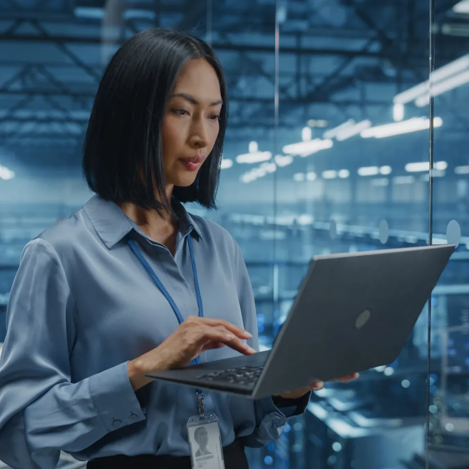 Fotografía de un experto en sistemas integrados de gestión revisando análisis en una tableta dentro de una oficina amplia.